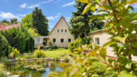Blick über den Garten auf das Haus - Teich mit KI - Haus + Bungalow mit vielen Gestaltungsmöglichkeiten & weiterem Baufeld in Potsdam