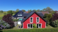 Seitenansicht rotes Haus - Maritimes Lebensgefühl zwischen Meer & Feld – Zwei nordische Schwedenhäuser mit Saunahaus zur Eigennutzung oder Ferienvermietung